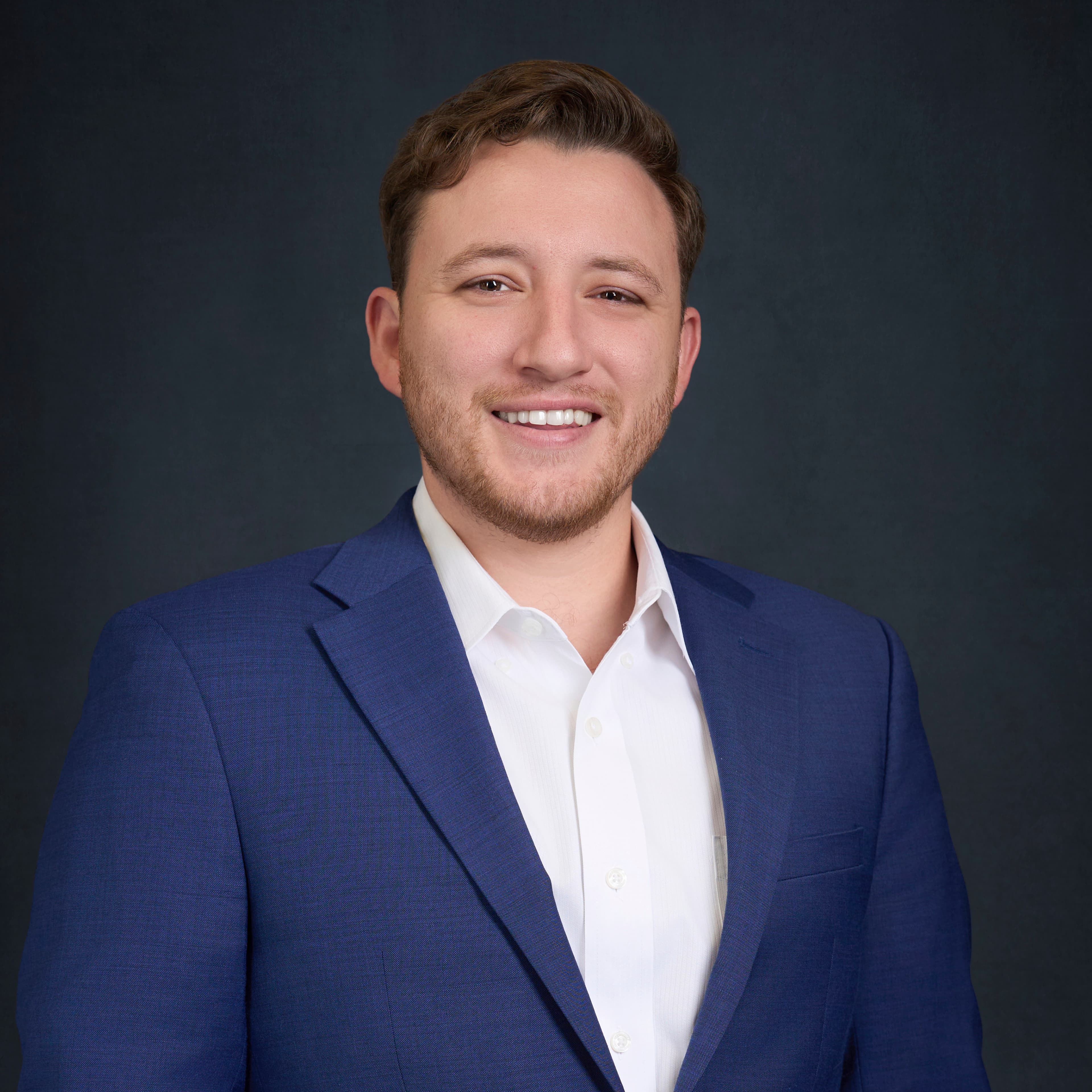 Studio portrait of Hunter Shields wearing a blue jacket and white shirt